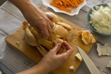 Ahşap kesme tahtası, çiğ tavuk hazırlama eller yakın çekim 