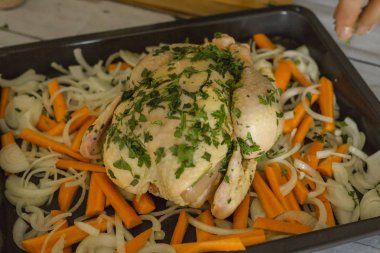 çiğ tavuk ve dilim soğan ve havuç ahşap arka plan üzerinde pişirme plaka 