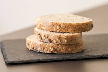 siyah arduvaz tahta üzerinde ev yapımı tahıllı ekmek dilimleri 