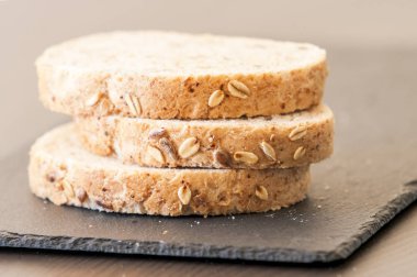 siyah arduvaz tahta üzerinde ev yapımı tahıllı ekmek dilimleri 