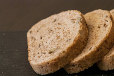 siyah arduvaz tahta üzerinde ev yapımı tahıllı ekmek dilimleri 