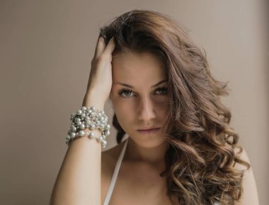 saç dokunmaktan ve evde kameraya bakarak çekici kahverengi saçlı kadın portresi