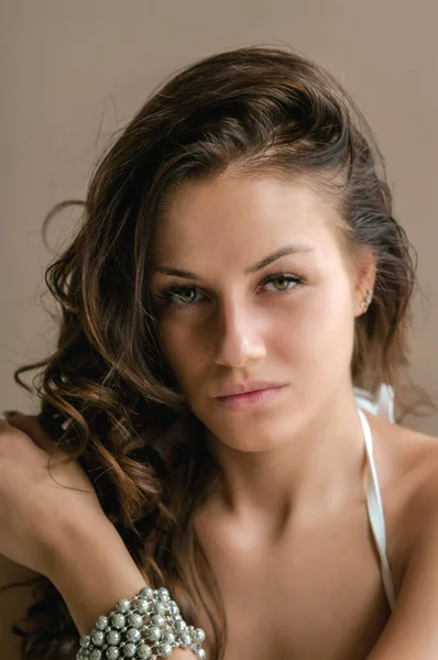 portrait of beautiful brown-haired girl looking at camera at home