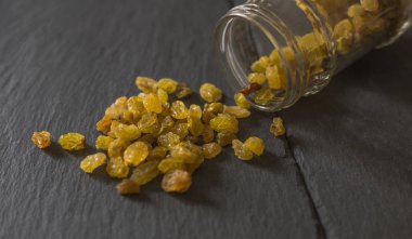 dağınık lezzetli kuru üzüm ve cam kavanoz mutfak masa üzerinde