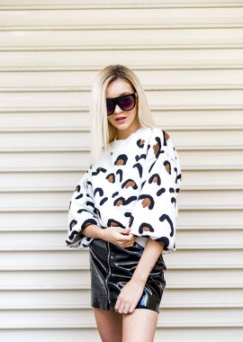 şık giysiler ve güneş gözlüğü duvar önünde çekici genç kadın portresi