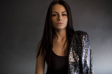 Stüdyoda poz veren leopar ceketli esmer kız.