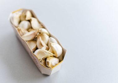 beyaz masada sarımsak karanfil ile kağıt konteyner