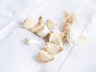 beyaz masa örtüsü üzerinde sarımsak karanfil ve kabukları