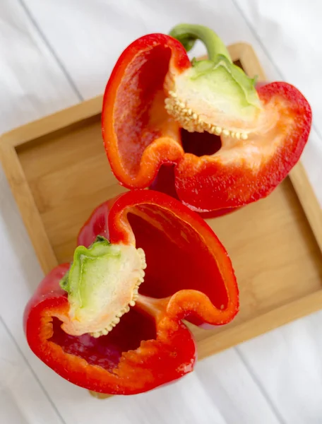 halves of red bell pepper on wooden board