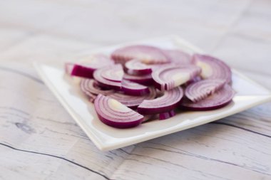 Bir tabakta doğranmış kırmızı soğan yakın