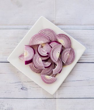 Bir tabakta doğranmış kırmızı soğan yakın