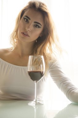 Hafif arka planda kırmızı şarap cam ile genç güzel kadın 