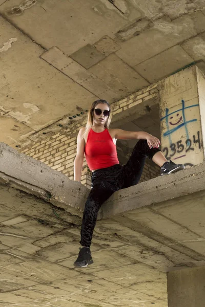 Sporty chic woman posing at abandoned construction site