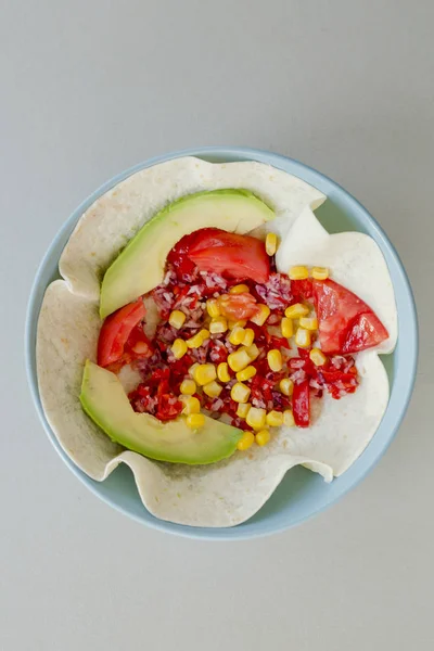 Mexican taco with vegetarian fillings in bowl on light table, cooking process