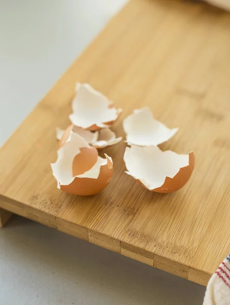 broken egg shell on wooden cutting board, close-up