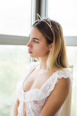 Güzel genç kadın iç çamaşırı giyen pencere yakınında poz 