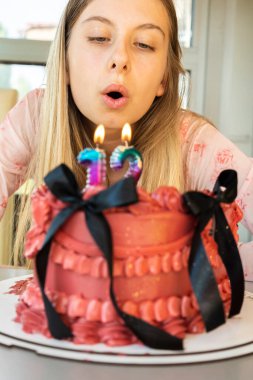 12 yaşındaki kız doğum günü kutlaması. Pasta mumları ve gülümsemeyle.