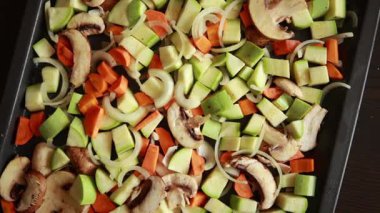 Taze kabak, havuç ve mantarların pişirme tepsisinde terbiye edilmiş ve pişirilmeye hazır olduğu samimi bir sonbahar videosu.