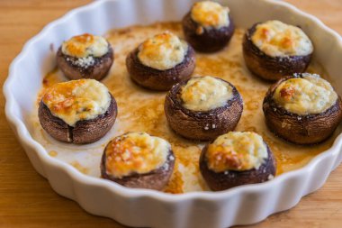 Krem peynirle doldurulmuş ve parmesanla kaplanmış fırında şampiyon mantarları. Sıcak sonbahar aperatifleri, parti atıştırmalıkları için mükemmel.