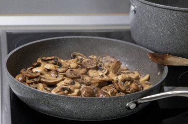 sliced mushrooms and onions sizzling in a hot pan