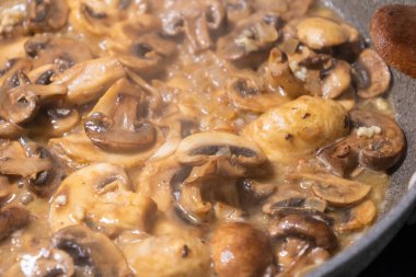 creamy mushroom sauce simmering in a pan with sauted mushrooms and onions