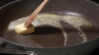 Tereyağı sıcak tavada yavaşça eriyor.