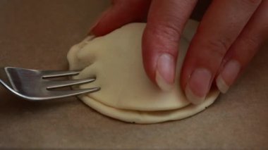 Eller peynirli mini turtalar, taze elma dilimleri ve puf börekleri hazırlıyor.