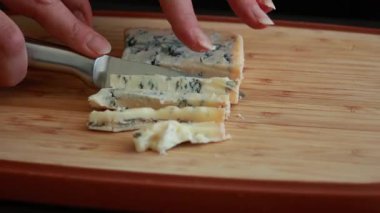 Kadınların elleri kremalı mavi peyniri küçük küplere ayırıyor.