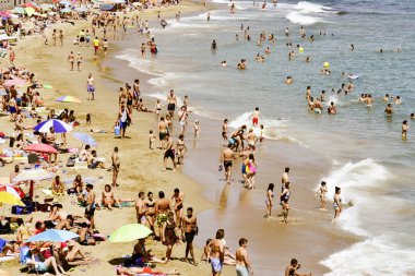 Sitges, İspanya - 9 Temmuz 2017: zevk, rahatlatıcı, güneşlenme veya Sitges, Metropolitan alan Barcelona, İspanya sahillerinin popüler bir plaj Garraf plajda banyo insanlar