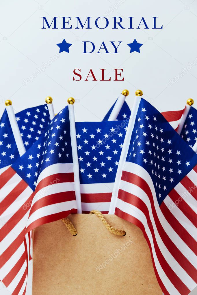 the text memorial day sale and a brown paper shopping bag with many flags of the United States