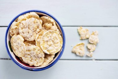 soluk yeşil ahşap bir masa üzerinde bir kase ile biraz kahvaltılık mısır ve quinoa kek, yüksek açılı görünüş