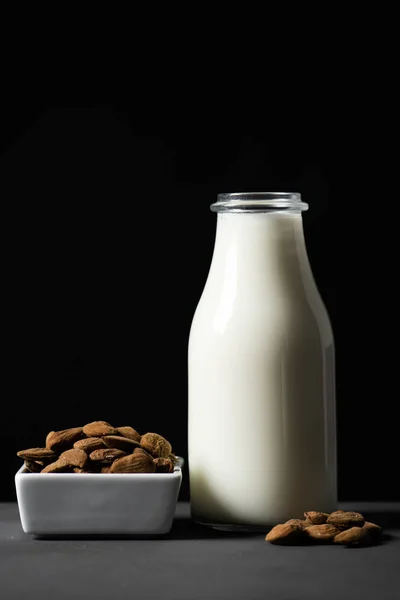 Closeup White Ceramic Bowl Almonds Glass Bottle Almond Milk Gray — Stock Photo, Image