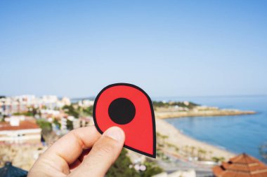 Tarragona, İspanya, şehrin ana plaj mucize Beach işaret eden kırmızı bir marker ile genç bir beyaz adamın elini closeup