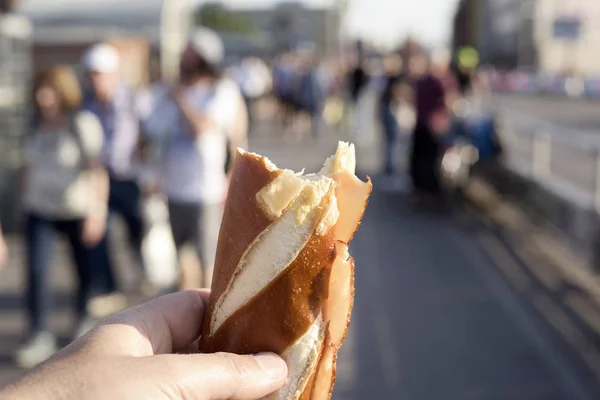 ドイツの Laugenstange で作られたサンドイッチを食べる白人男のクローズ アップ ロールイン屋外鉄道やトラム駅 — ストック写真
