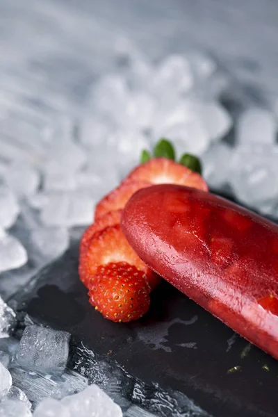 Closseup 自制的冰弹出与天然草莓 在自然石板托盘周围的冰 — 图库照片