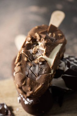 biraz çikolatalı dondurma çubukları rustik ahşap bir masa yerleştirilen bir kesme tahtası üzerinde closeup