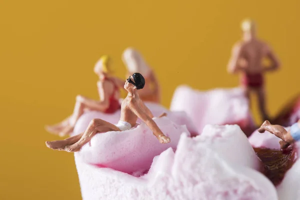 Nahaufnahme Einiger Miniaturmenschen Badeanzug Die Sich Auf Einer Vorgefüllten Eistüte — Stockfoto