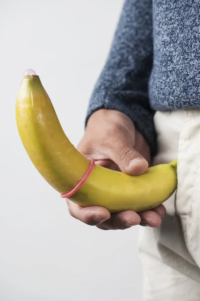 Closeup Dari Seorang Pemuda Kaukasia Memegang Pisang Dengan Kondom Merah — Stok Foto