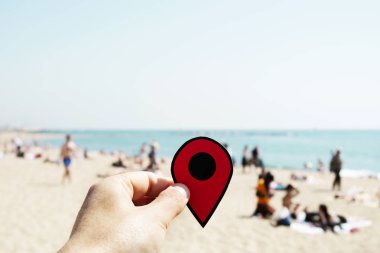 Barselona, İspanya, La Barceloneta Beach tanınmayan insanlar arka planda güneşlenme ile kırmızı bir marker ile genç bir beyaz adamın elini closeup