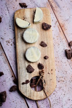 Bazı Arjantin-Uruguay alfajores dulce de leche ile dolu ve rustik bir tabloda bir Ahşap Doğrama tahtası üzerinde beyaz bir kaplama ile kaplı, yüksek açılı görünüş