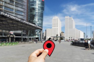 Berlin, Almanya - 24 Mayıs 2018: Potsdamer Platz'ta birçok yeni binalar, Berlin duvarının yıkılmasından sonra ile şehrin önemli bir kare kırmızı bir marker ile genç bir adamın elini