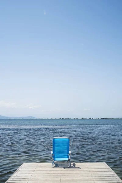 Une Chaise Longue Bleue Bout Une Jetée Bois Côté Eau — Photo