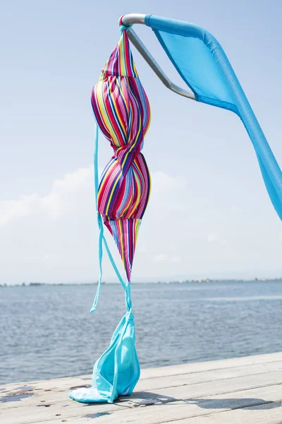 Colorful Bikini Drying Blue Deck Chair Wooden Pier Next Water — Stock Photo, Image