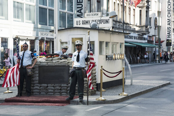 BERLIN, GERMANY - MAY 25, 2018: Fake US officers at the popular Checkpoint Charlie, a reproduction in the middle of the street of the historic crossing point between East Berlin and West Berlin