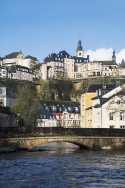 Alzette Nehri olarak bir görünümünü Lüksemburg Şehri, Lüksemburg, Grund çeyreğinde ve Ville Haute çeyrek ile Saint-Michel kilisenin çan kulesi vurgulayarak üstüne geçer