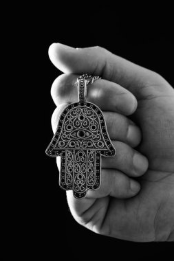 closeup fatima'nın el veya mary, el Siyah beyaz da bilinen eski bir hamsa muska tutan bir genç adamın elini