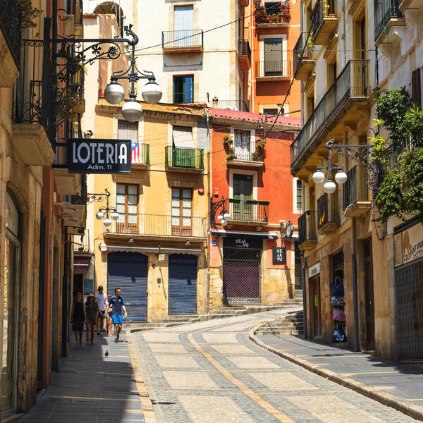 TARRAGONA, SPAIN - JULY 28, 2018: The Baixada de la Misericordia street in the Part Alta, the Old Town of Tarragona, Spain, with its colorful buildings and its characteristic cobblestone pavement