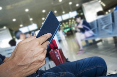 tatlı genç bir beyaz adam bir tren veya otobüs istasyonu veya bir havaalanı bekleme odasında bir kitap okuma