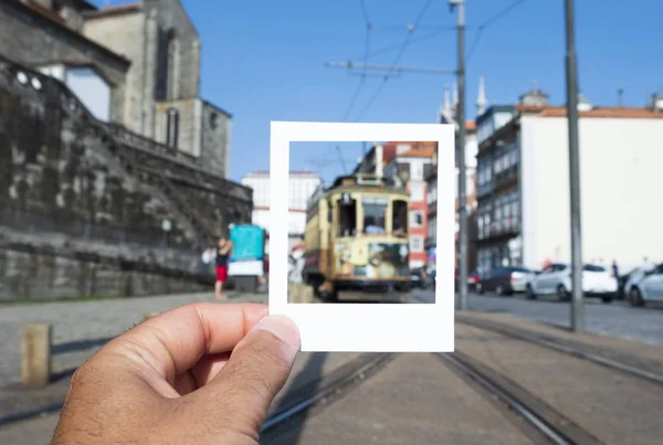 特写一个年轻的白人男子与白色纸板框架在他的手 模拟一张即时照片 在葡萄牙波尔图老城的典型旧电车框架 — 图库照片