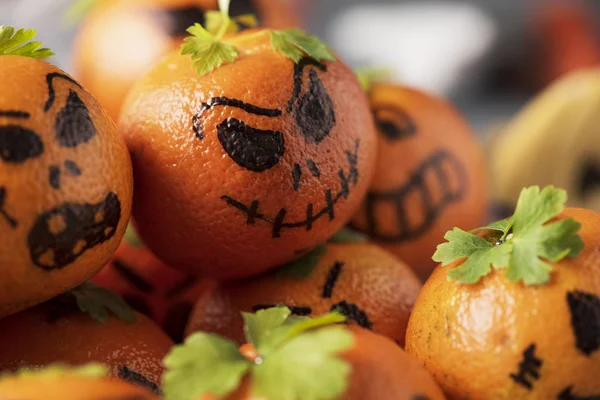 几个橘子作为雕刻鬼脸南瓜装饰的特写 — 图库照片